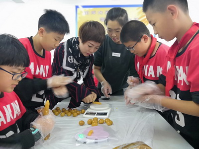 王红校长和学生们在制作月饼